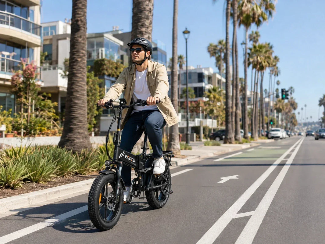 Helmeted rider on an EMOKO folding e-bike in a California-style coastal city bike lane