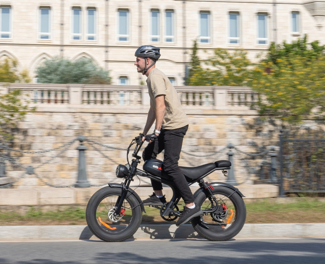 A rider commuting on the EMOKO C93 moped-style electric bike in a city environment, demonstrating urban riding comfort and speed.